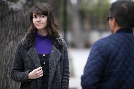 Woman walking outdoors in the city and looking snobby while running into an ex boyfriend or looking annoyed by an insulting stranger.  It also depicts social anxiety.の写真素材