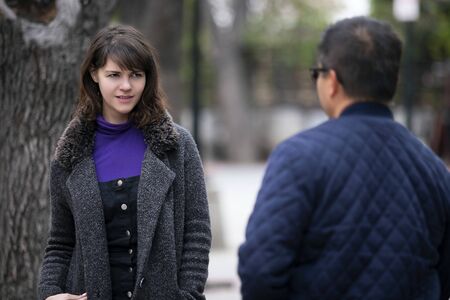 Woman walking outdoors in the city and looking snobby while running into an ex boyfriend or looking annoyed by an insulting stranger.  It also depicts social anxiety.の写真素材