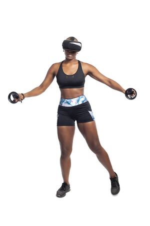 Black African American woman working out by playing a VR dancing rhythm video game while wearing a virtual reality headset.  Depicts esports technology and active lifestyle.の写真素材