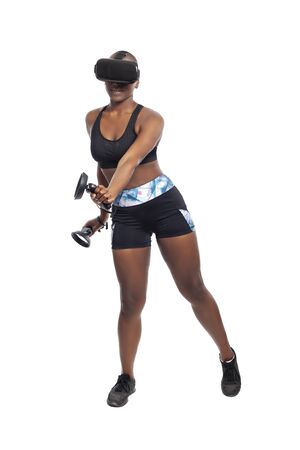 Black African American woman working out by playing a VR dancing rhythm video game while wearing a virtual reality headset.  Depicts esports technology and active lifestyle.の写真素材