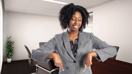 Black African American businesswoman in an office advertising or presenting something.  She is an owner or an executive of the workplace.  Depicts careers and startup business.の写真素材