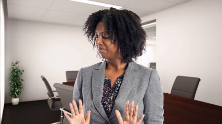 Black African American businesswoman in an office looking disgusted.  She is an owner or an executive of the workplace.  Depicts careers and startup business.の写真素材