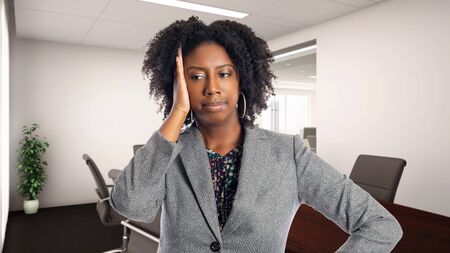 Black African American businesswoman in an office making a mistake.  She is an owner or an executive of the workplace.  Depicts careers and startup business.の写真素材