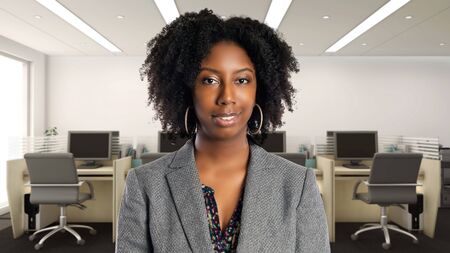 Black African American businesswoman in an office smiling happy.  She is an owner or an executive of the workplace.  Depicts careers and startup business.の写真素材
