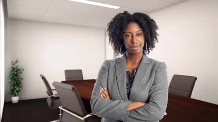 Black African American businesswoman in an office looking confident or arrogant.  She is an owner or an executive of the workplace.  Depicts careers and startup business.の写真素材