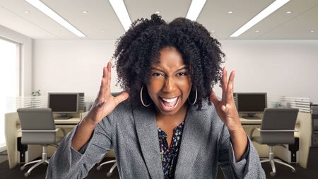 Black African American businesswoman in an office looking angry.  She is an owner or an executive of the workplace.  Depicts careers and startup business.の写真素材