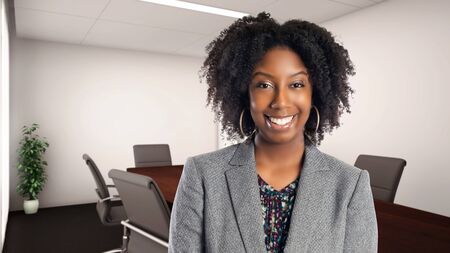 Black African American businesswoman in an office smiling happy.  She is an owner or an executive of the workplace.  Depicts careers and startup business.の写真素材