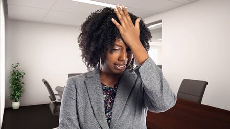 Black African American businesswoman in an office making a mistake.  She is an owner or an executive of the workplace.  Depicts careers and startup business.の写真素材