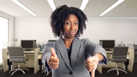 Black African American businesswoman in an office looking confused.  She is an owner or an executive of the workplace.  Depicts careers and startup business.の写真素材