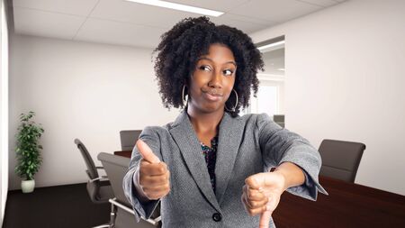 Black African American businesswoman in an office looking confused.  She is an owner or an executive of the workplace.  Depicts careers and startup business.の写真素材