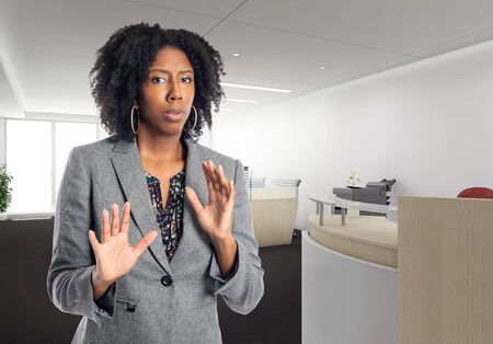 Black African American businesswoman in an office looking scared.  She is an owner or an executive of the workplace.  Depicts careers and startup business.の写真素材