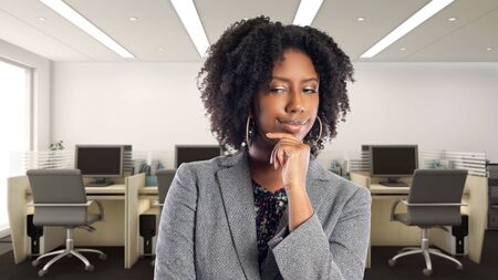 Black African American businesswoman in an office thinking of ideas.  She is an owner or an executive of the workplace.  Depicts careers and startup business.の写真素材
