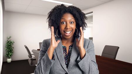 Black African American businesswoman in an office looking surprised.  She is an owner or an executive of the workplace.  Depicts careers and startup business.の写真素材
