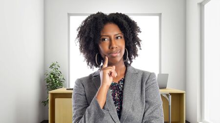 Black African American businesswoman in an office thinking of ideas.  She is an owner or an executive of the workplace.  Depicts careers and startup business.の写真素材