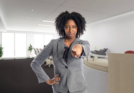 Black African American businesswoman in an office pointing forward.  She is an owner or an executive of the workplace.  Depicts careers and startup business.の写真素材