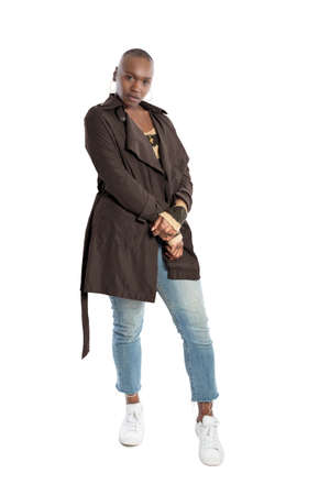 Black African American fashion model with bald hairstyle confidently posing with a coffee brown colored jacket for fall collection.  Depicts fashion design and clothing apparelの写真素材