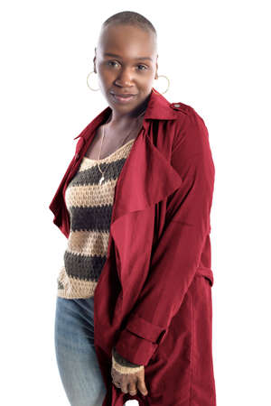 Black African American fashion model with bald hairstyle confidently posing with a coffee brown colored jacket for fall collection.  Depicts fashion design and clothing apparelの写真素材