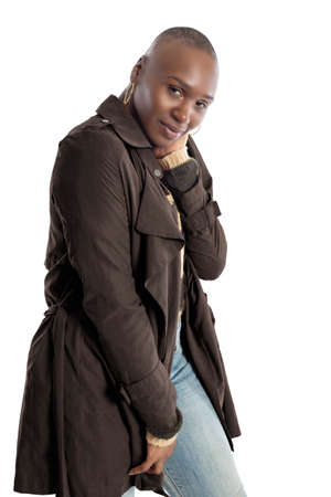 Black African American fashion model with bald hairstyle confidently posing with a coffee brown colored jacket for fall collection.  Depicts fashion design and clothing apparelの写真素材