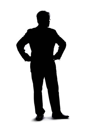 Full body silhouette of a businessman isolated on a white background. He is standing and waiting and posed as if bored or impatient.の写真素材