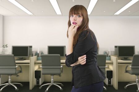Businesswoman or office worker looking upset and anxious because she is alone in the workplace.  She looks worried about failure or lack of employees. の写真素材
