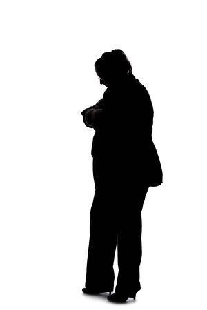Silhouette of a curvy or plus size businesswoman on a white background.  She is posed like she is bored of waiting and standing.の写真素材