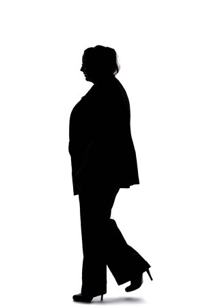 Silhouette of a curvy or plus size businesswoman on a white background.  She is posed like she is walking in side view.の写真素材