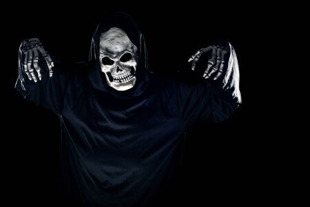 Scary monster or grim reaper ghost coming out of the dark shadows to haunt during Halloween.  Depicts a scary and deadly fictitious demonの写真素材