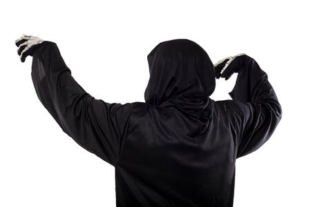 The grim reaper or death halloween costume isolated on a white background.  The skeleton is wearing a hooded black robe. Side view in profile for composites.の写真素材