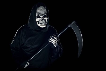 Grim Reaper ghost coming out of the shadows with a scythe or sickle.  The scary demon or monster depicts Halloween and Day of the Dead holiday.の写真素材