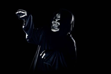 Scary monster or grim reaper ghost coming out of the dark shadows to haunt during Halloween.  Depicts a scary and deadly fictitious demonの写真素材