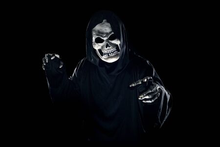 Scary monster or grim reaper ghost coming out of the dark shadows to haunt during Halloween.  Depicts a scary and deadly fictitious demonの写真素材