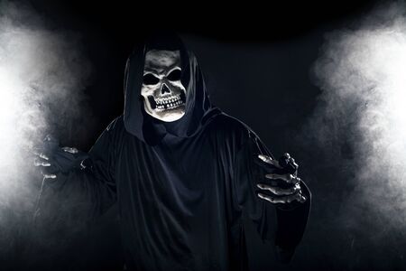 Scary looking grim reaper ghost coming out of the foggy mist.  The haunting creepy demon depicts death and evil and is a common Halloween theme as well as Day of the Dead.の写真素材