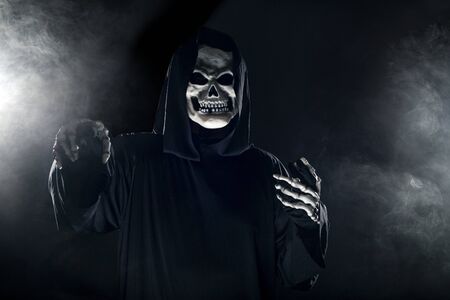 Scary looking grim reaper ghost coming out of the foggy mist.  The haunting creepy demon depicts death and evil and is a common Halloween theme as well as Day of the Dead.の写真素材