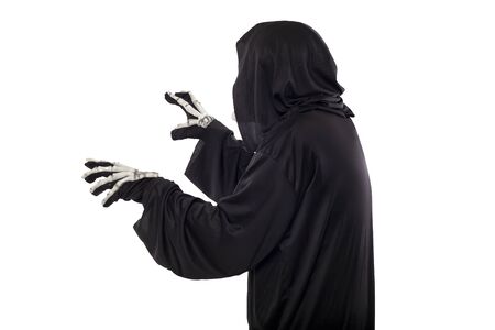 The grim reaper or death halloween costume isolated on a white background.  The skeleton is wearing a hooded black robe. Side view in profile for composites.の写真素材