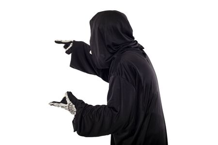 The grim reaper or death halloween costume isolated on a white background.  The skeleton is wearing a hooded black robe. Side view in profile for composites.の写真素材