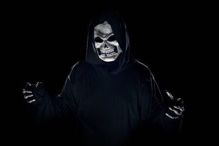 Scary monster or grim reaper ghost coming out of the dark shadows to haunt during Halloween.  Depicts a scary and deadly fictitious demonの写真素材