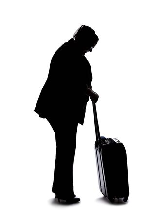 Silhouette of a businesswoman going on a business trip and traveling with luggage.  She is carrying bags like preparing to board a flight at an airport. の写真素材