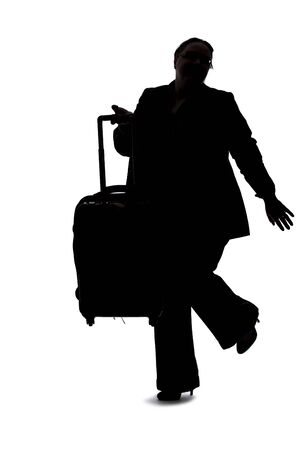 Silhouette of a businesswoman going on a business trip and traveling with luggage.  She is carrying bags like preparing to board a flight at an airport. の写真素材