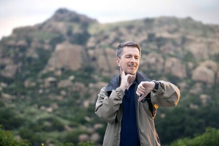 Middle aged man staying healthy by doing outdoor activities during a nature getaway vacation.  He is hiking through the mountains and enjoying the peace and serenity.の写真素材