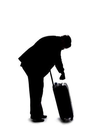 Silhouette of a businesswoman going on a business trip and traveling with luggage.  She is carrying bags like preparing to board a flight at an airport.の写真素材