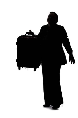 Silhouette of a businesswoman going on a business trip and traveling with luggage.  She is carrying bags like preparing to board a flight at an airport.の写真素材