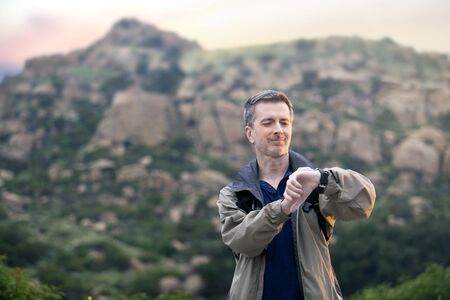 Middle aged man staying healthy by doing outdoor activities during a nature getaway vacation.  He is hiking through the mountains and enjoying the peace and serenity.の写真素材