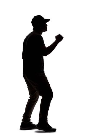 Silhouette of a man wearing casual clothes isolated on a white background. He is punching and hitting somethingの写真素材