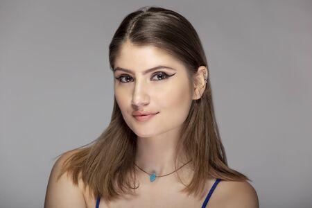 Beautiful female fashion model headshot posing with cosmetic eyeliner make up.  The close up portrait shows natural and simple style makeupの写真素材