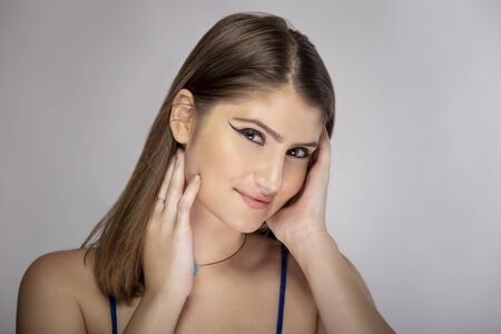 Beautiful female fashion model headshot posing with cosmetic eyeliner make up.  The close up portrait shows natural and simple style makeupの写真素材