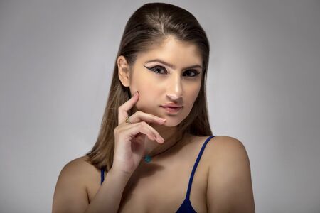 Beautiful female fashion model headshot posing with cosmetic eyeliner make up.  The close up portrait shows natural and simple style makeupの写真素材