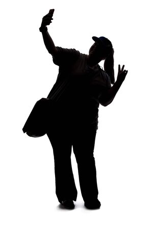 Silhouette of a curvy or plus size woman on a white background.  She is takign a selfie or streaming video online for social media as an influencerの写真素材