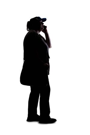 Silhouette of a curvy or plus size woman on a white background.  She is unrecognizable and using a cell phone or smartphoneの写真素材