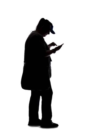 Silhouette of a curvy or plus size woman on a white background.  She is unrecognizable and using a cell phone or smartphoneの写真素材