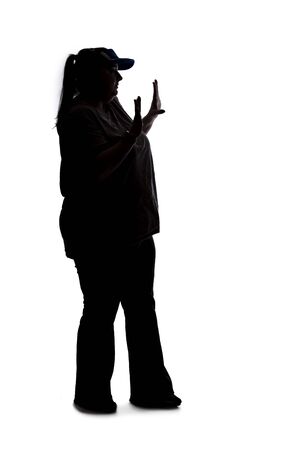 Silhouette of a curvy or plus size woman on a white background.  She is unrecognizable holding hands up as a stop gestureの写真素材